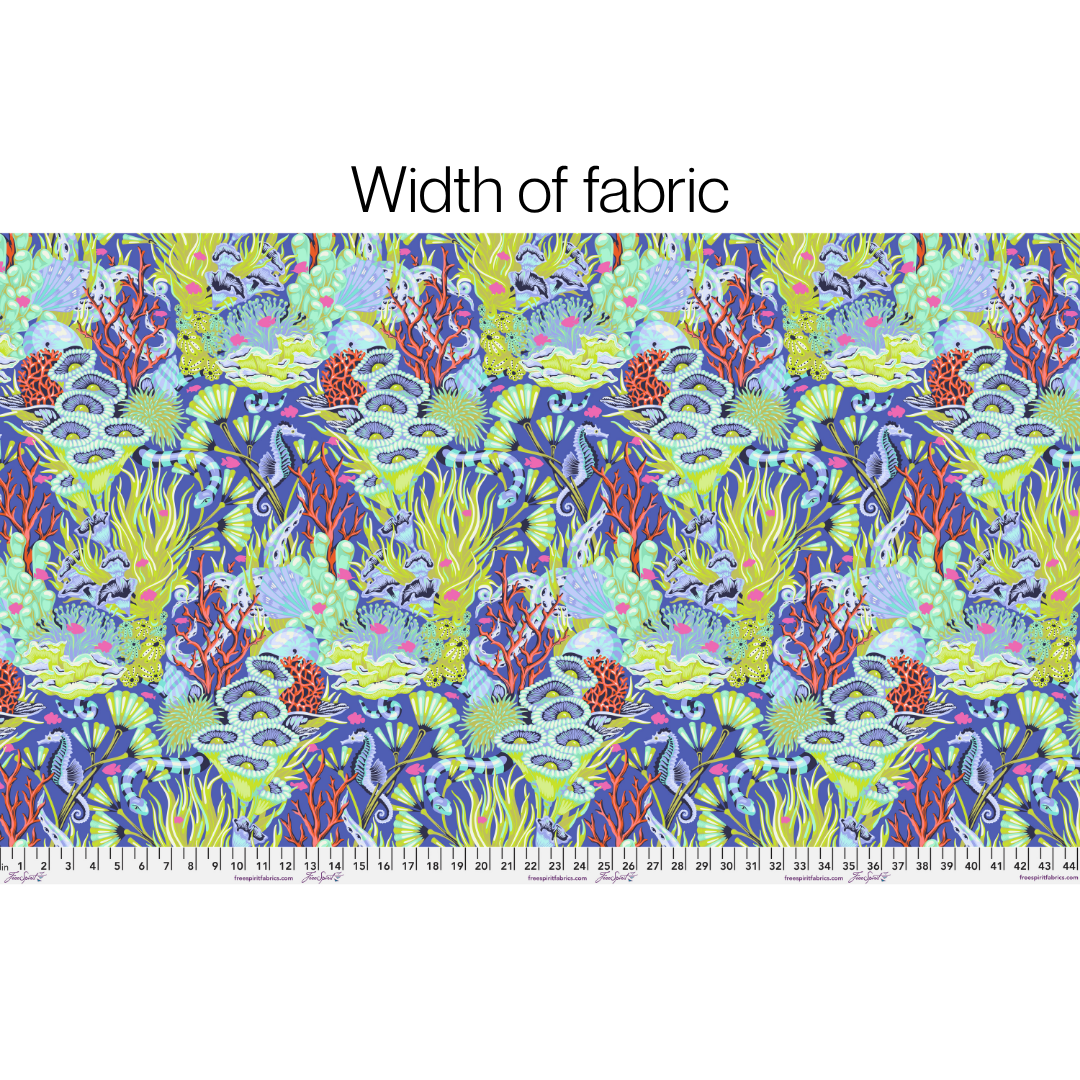 Fabric swatch with a lush underwater print filled with coral, sea plants, shells, seahorses, and other ocean details on a rich marine blue background with a ruler at the bottom. Print shown as width of fabric.