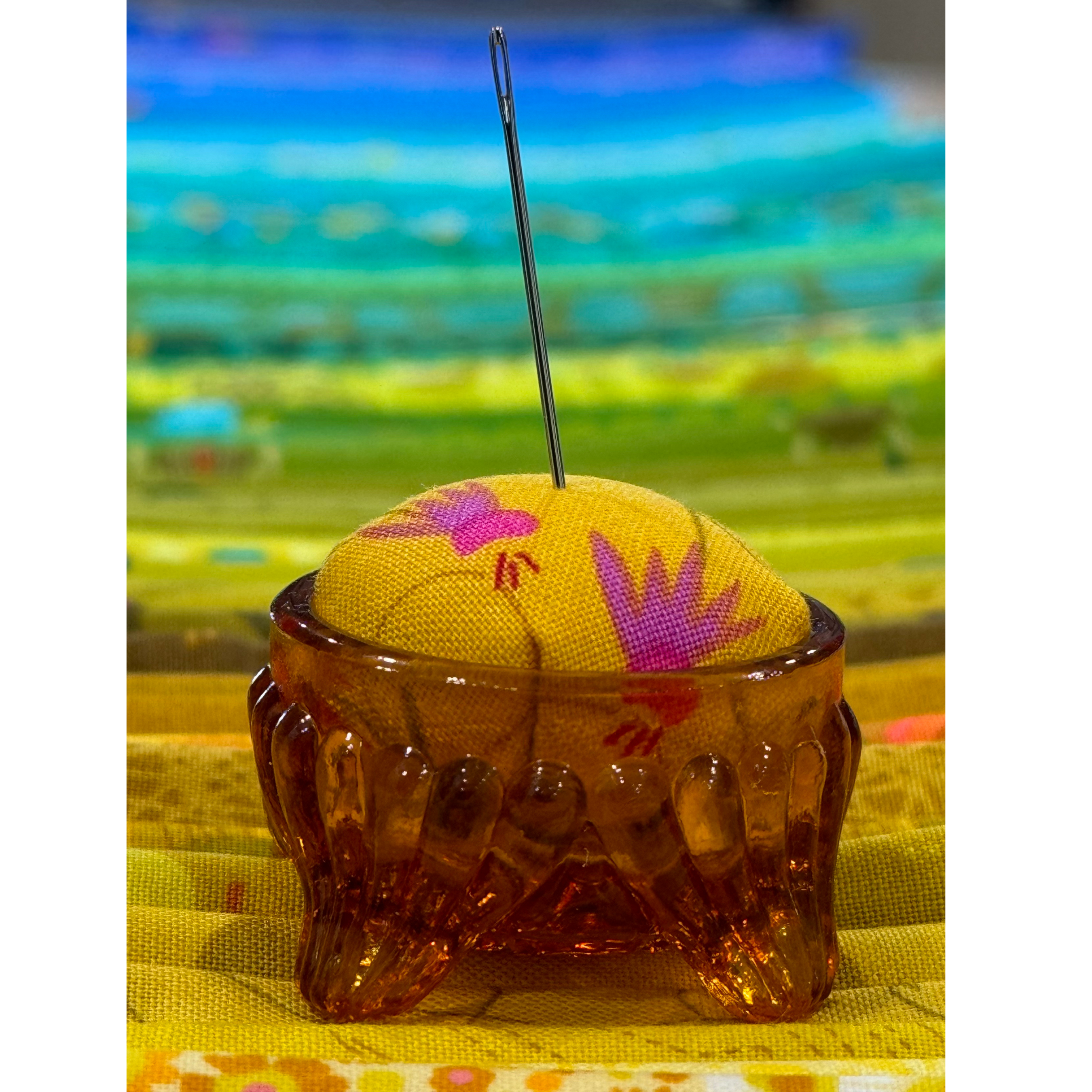 Pincushion in a salt cellar with brightly colored fabric